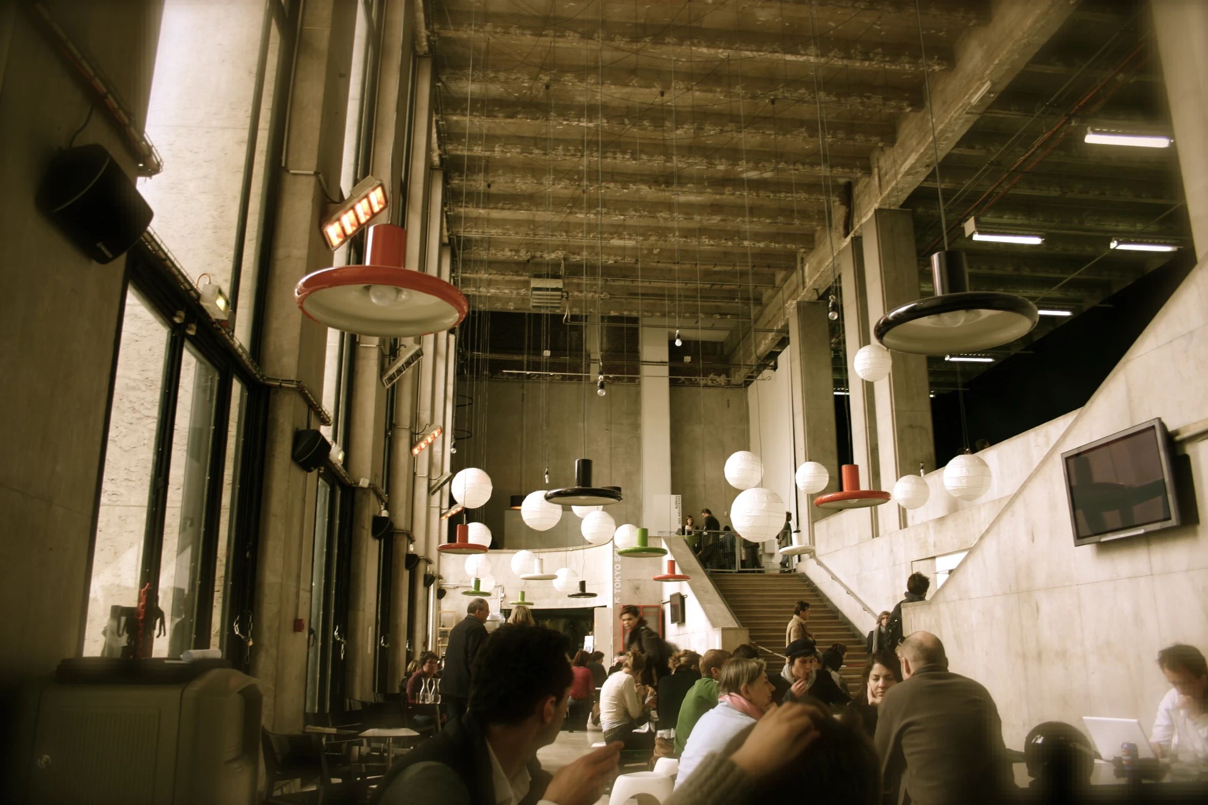 a very long narrow hallway with people sitting and standing