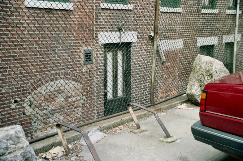 a red van parked next to a metal gate and gate