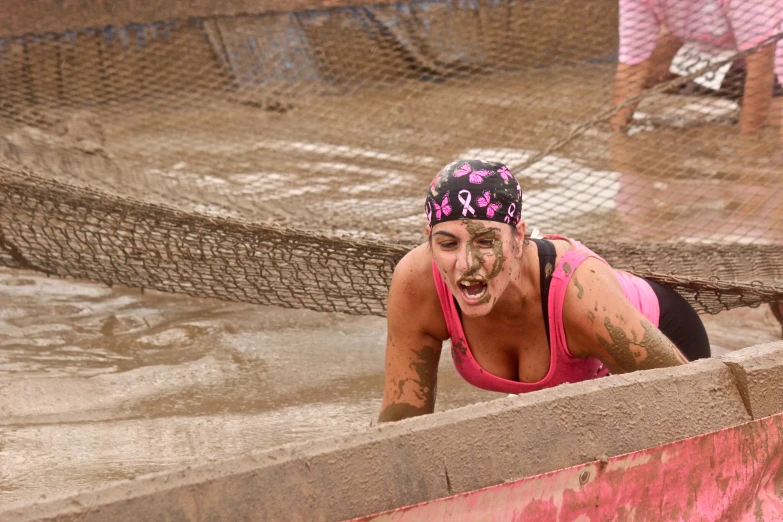 a woman in pink swimsuit covered in mud