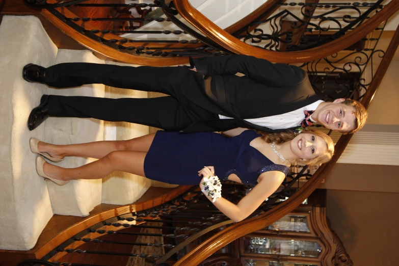 two people in evening wear standing on steps at formal event