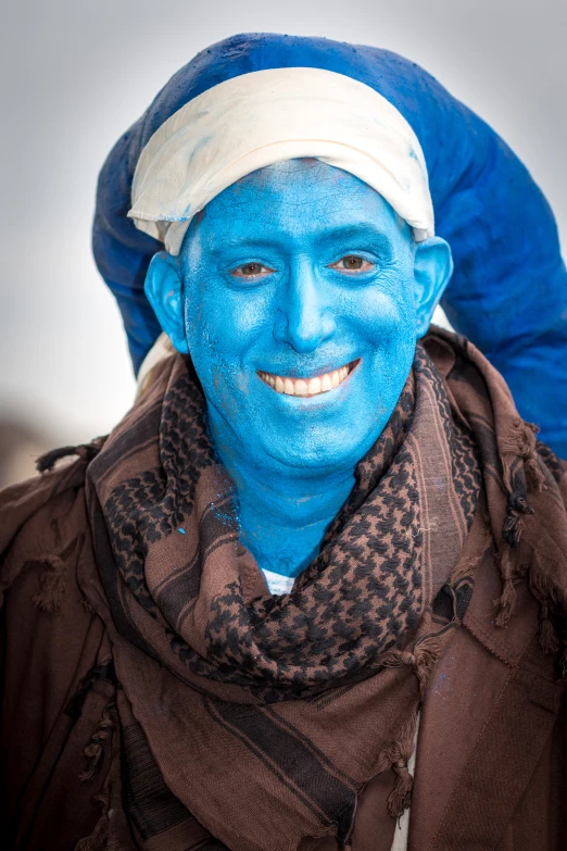 a man with a blue face painted in different colors