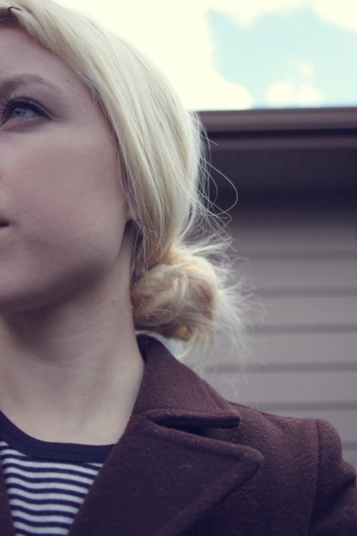 a woman with blonde hair in a bun and striped shirt