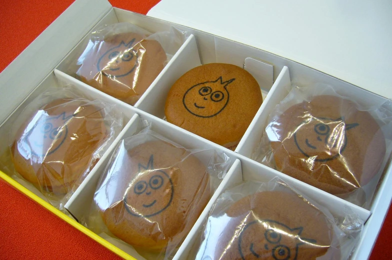 twelve decorated cookies sitting in the middle of a box