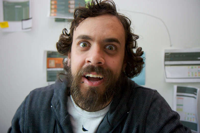 a man with a beard standing in an office