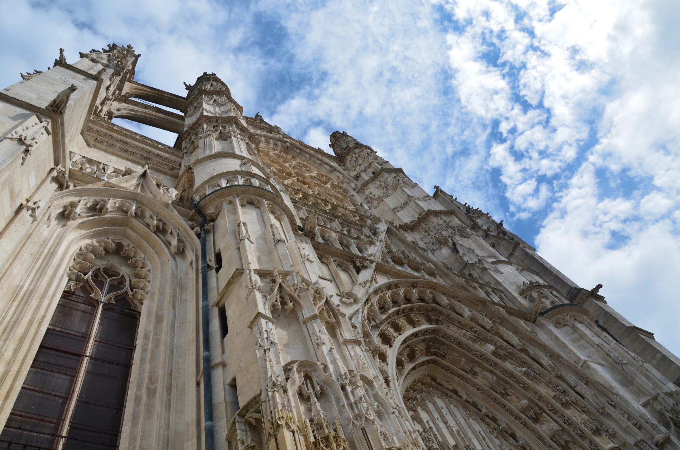 large and old building with several spires with clouds in the sky