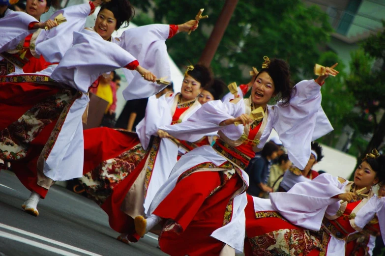 a group of women who are dancing together in the street