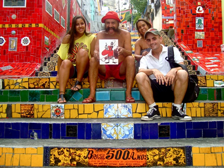 a group of people sitting down on a colorful set of stairs