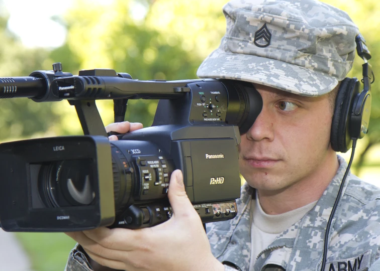 a soldier holding a video camera in his hand