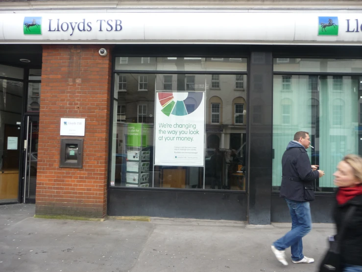 a man walking past a business that sells cds