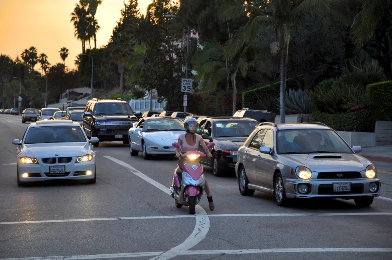 a woman on a motorcycle is stopped at a stop sign