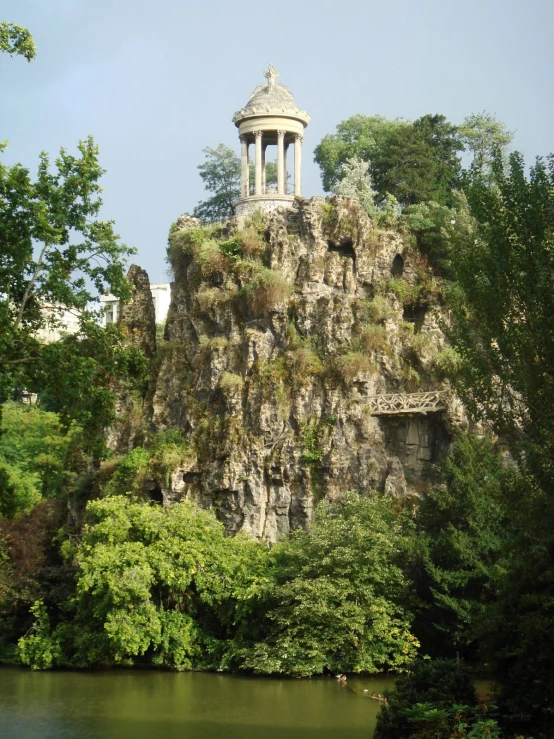 the structure near the water is made of rocks and has a clock tower