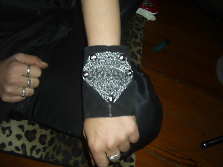 a woman wearing a black wrist watch and wearing a black purse
