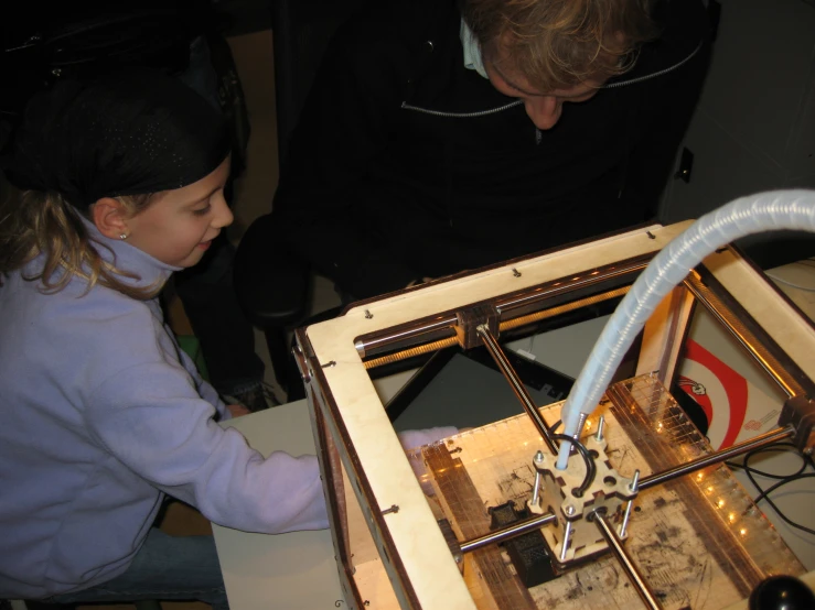 a little girl at an electronic machine making soing