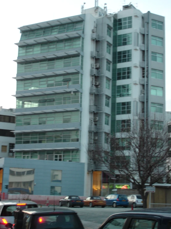 a tall building with a parking lot and lots of windows