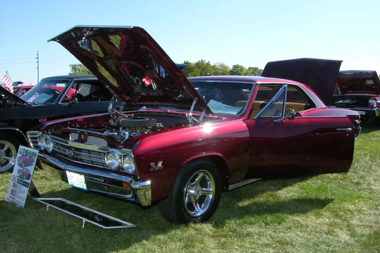 an old, red car is on display with other old classic cars