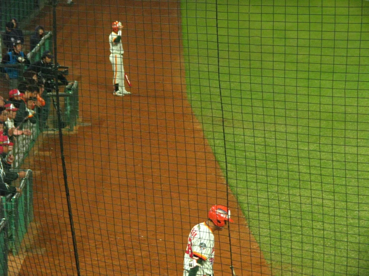 several men playing baseball in a field behind a fence