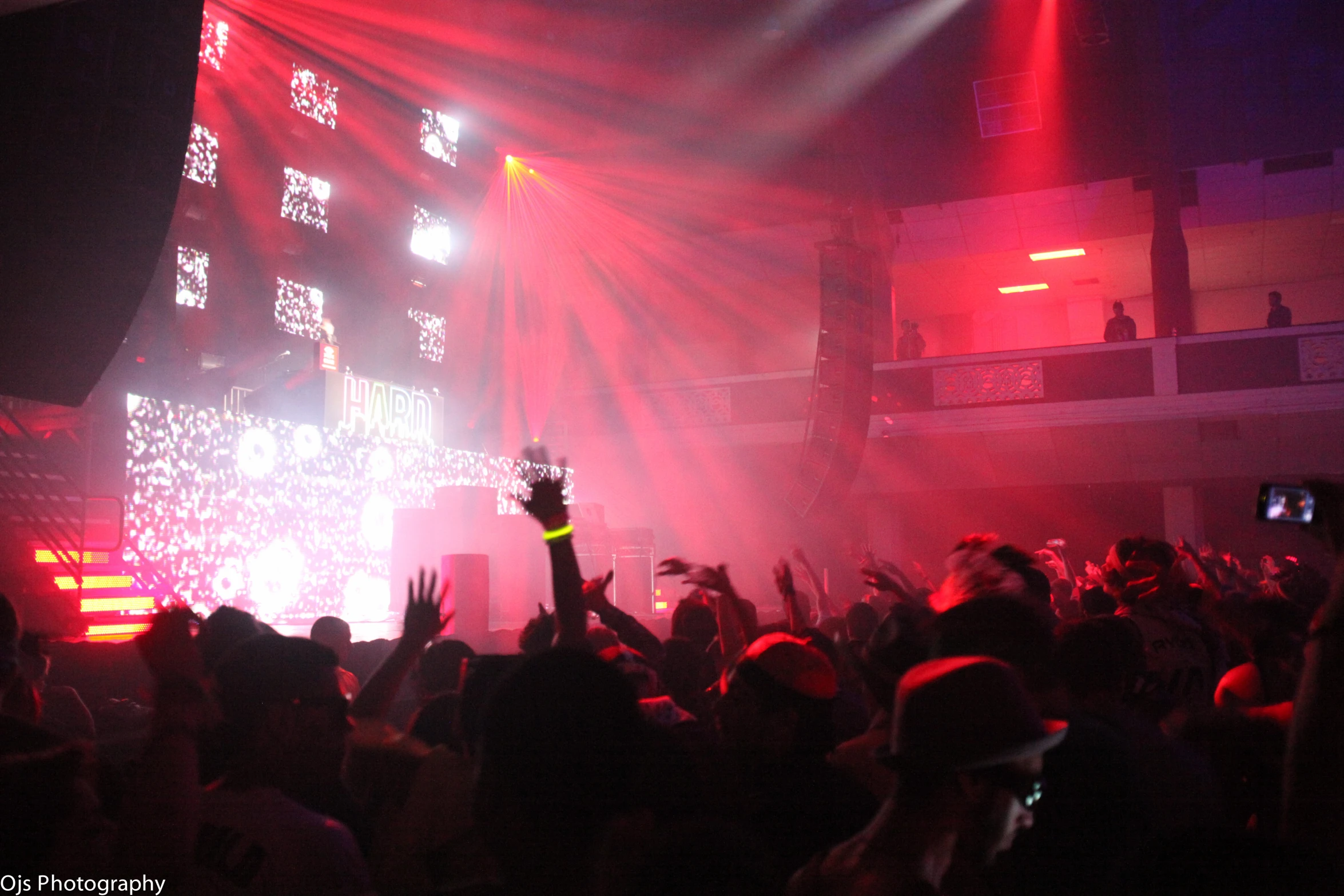 a concert scene with people raising their hands to make a gesture