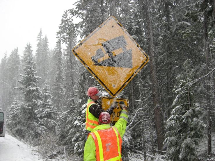 the snow covered forest has a warning sign on it