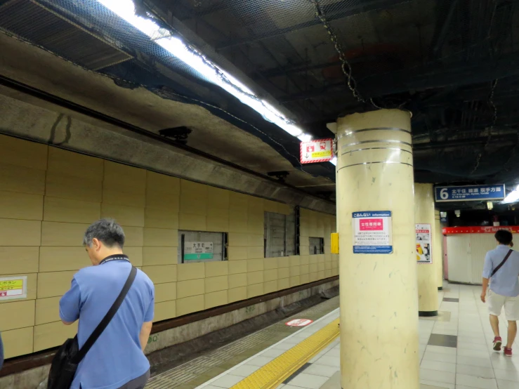 a couple of men walking across a subway station