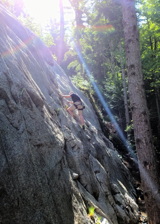 a man is on the side of a cliff doing a rock climb