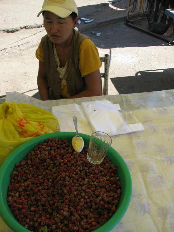 a lady sits behind a big bowl of berries