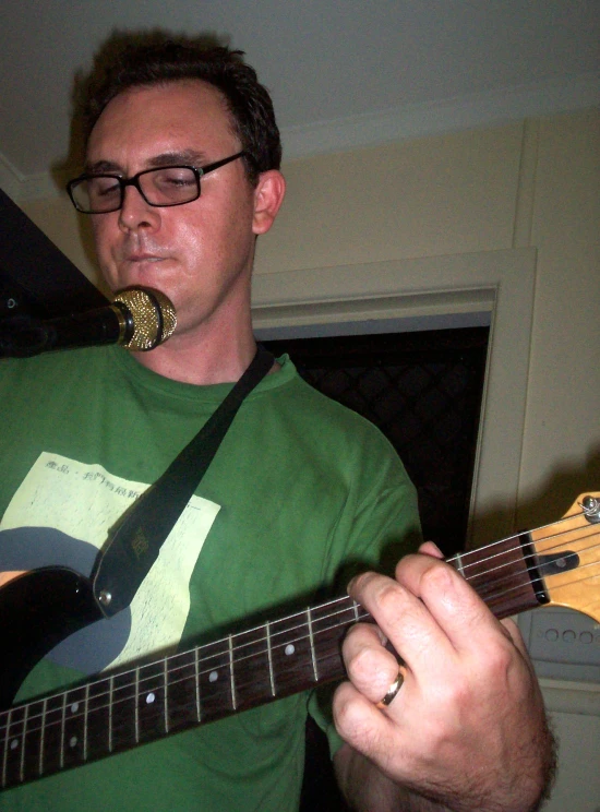 a man in glasses playing an electric guitar