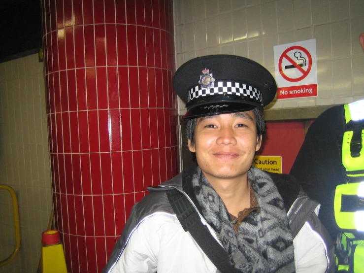 a young man wearing a police hat in a subway