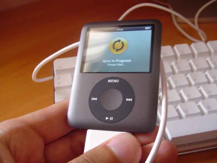 a person is holding an mp3 player with a cord in their hand