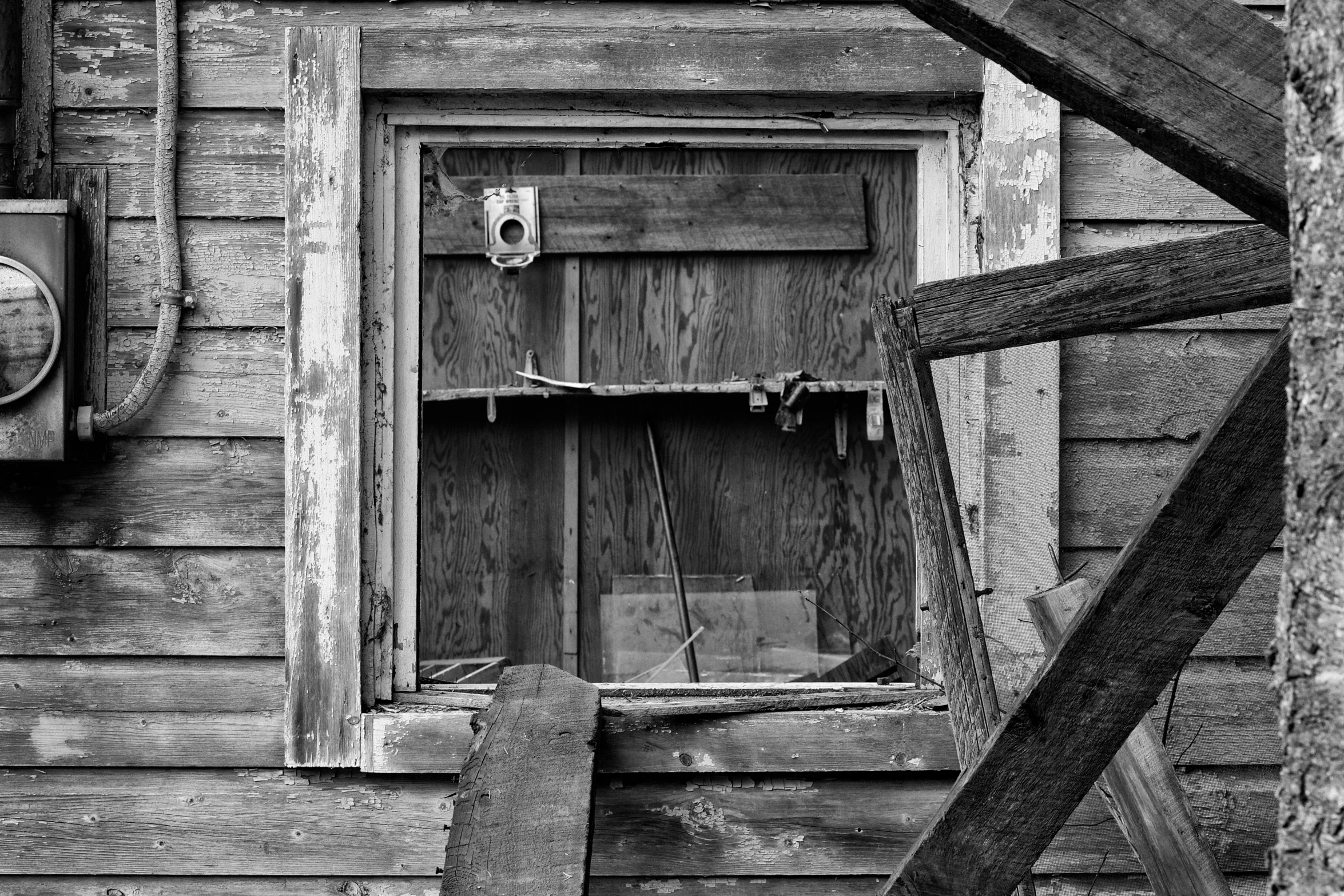 a black and white pograph of a door in a small wooden building