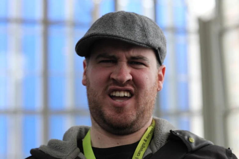 a man wearing a hat and jacket making a silly face