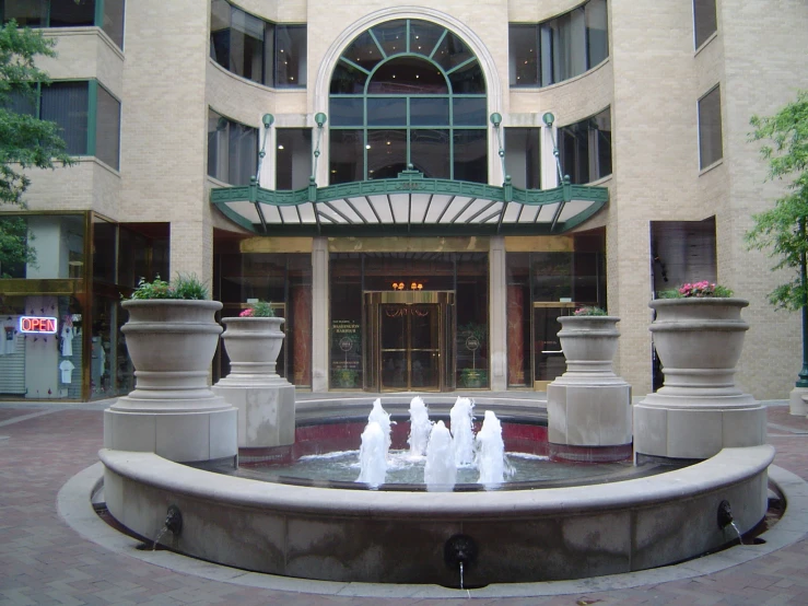 a group of fountain sitting in front of a tall building