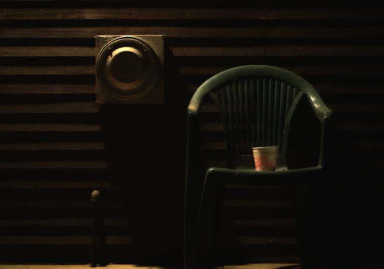 a dark room with a chair, a radio and a clock