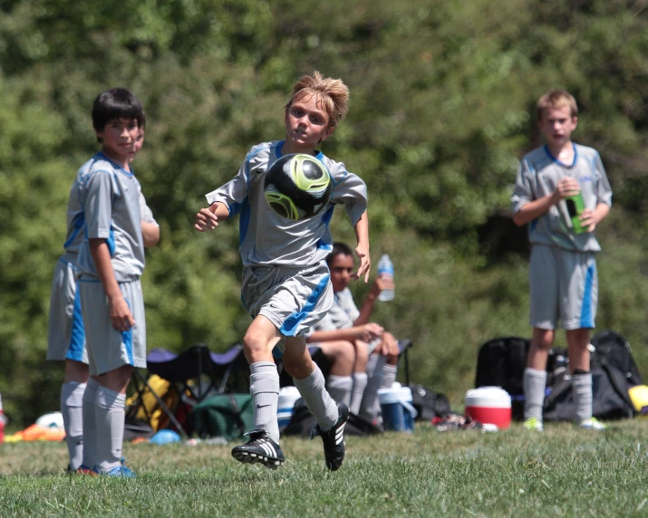 a young man chasing after the soccer ball