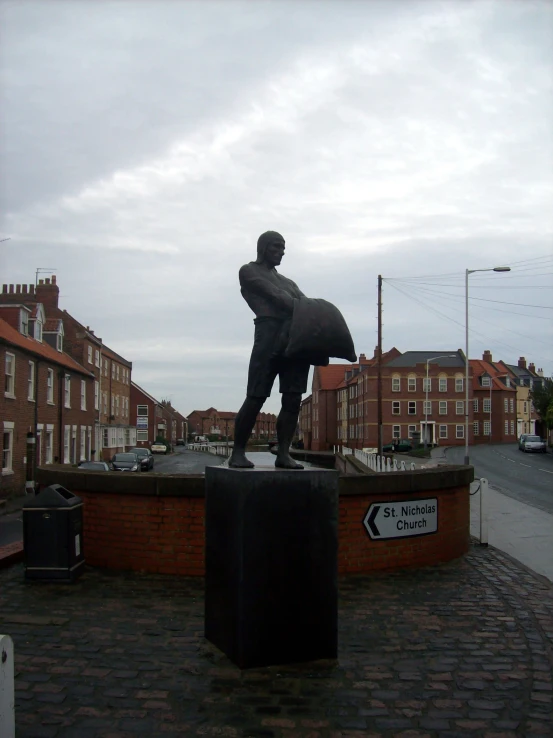 a statue in the middle of a cobblestone road