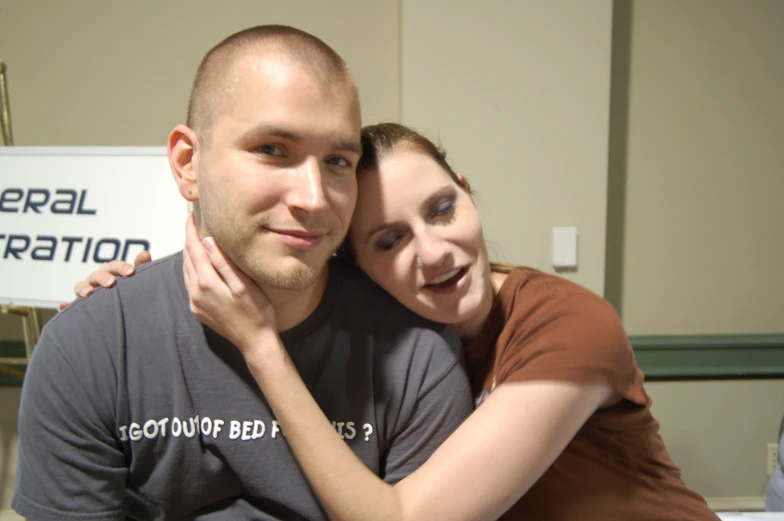 a man is hugging a woman with her arm on his chest