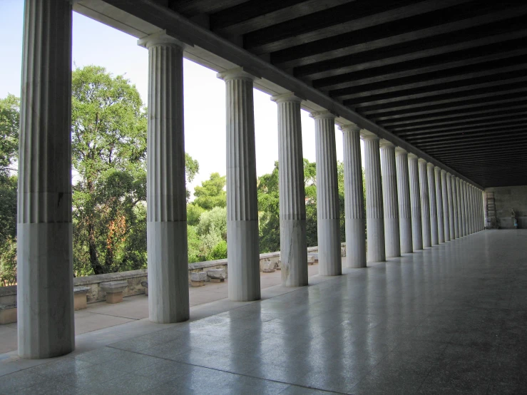 rows and columns line a walkway outside of a building