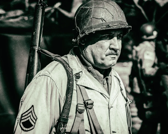 black and white pograph of a man with an old war uniform holding a stick