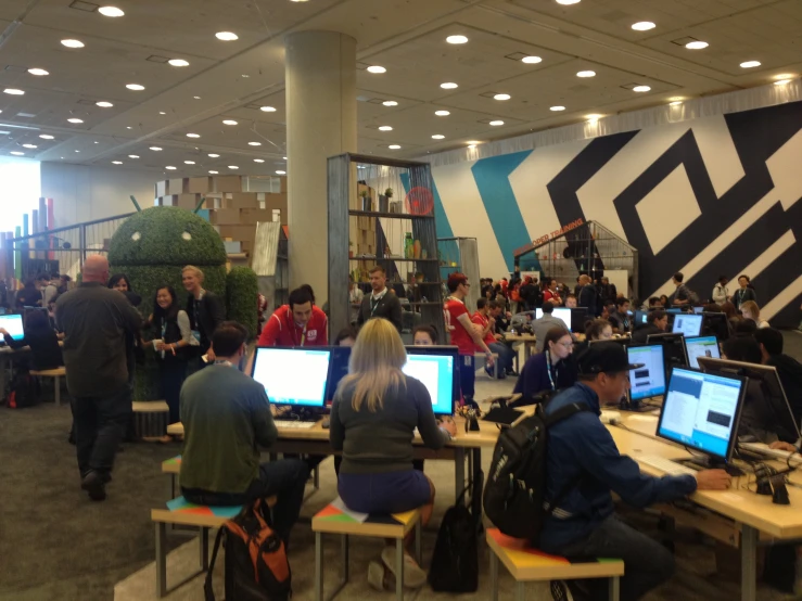 a large room filled with people working on laptop computers