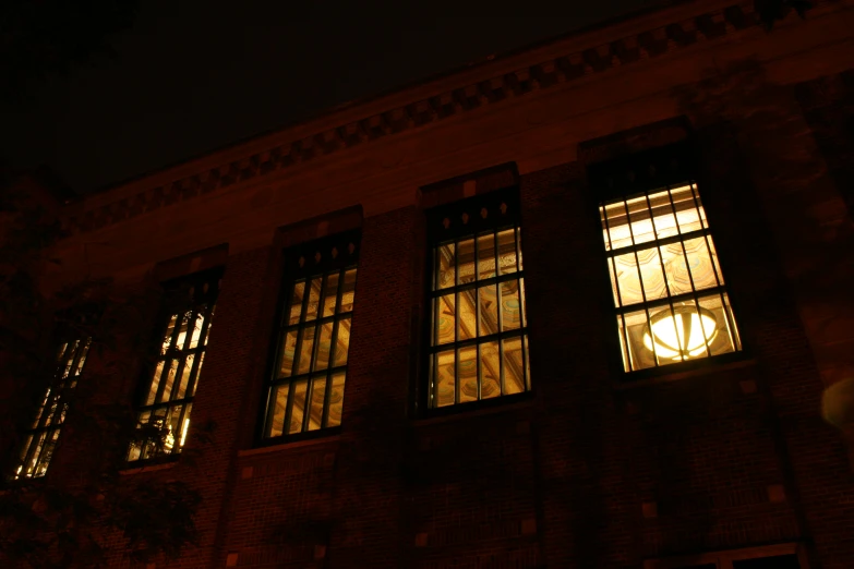 three windows that are lit up in the night