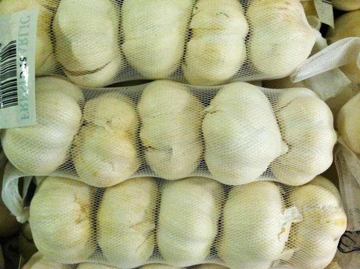 bags are piled high with garlic, on display