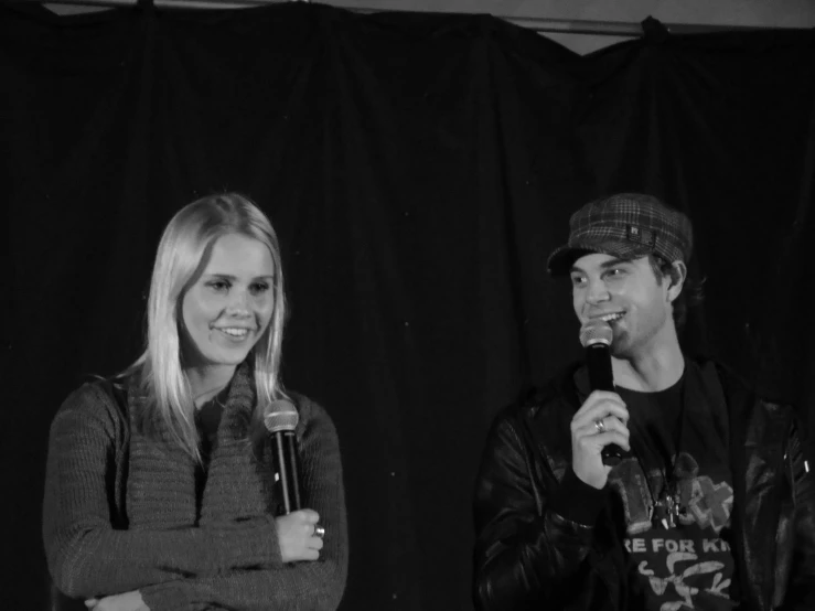 a man and woman that are holding a microphone