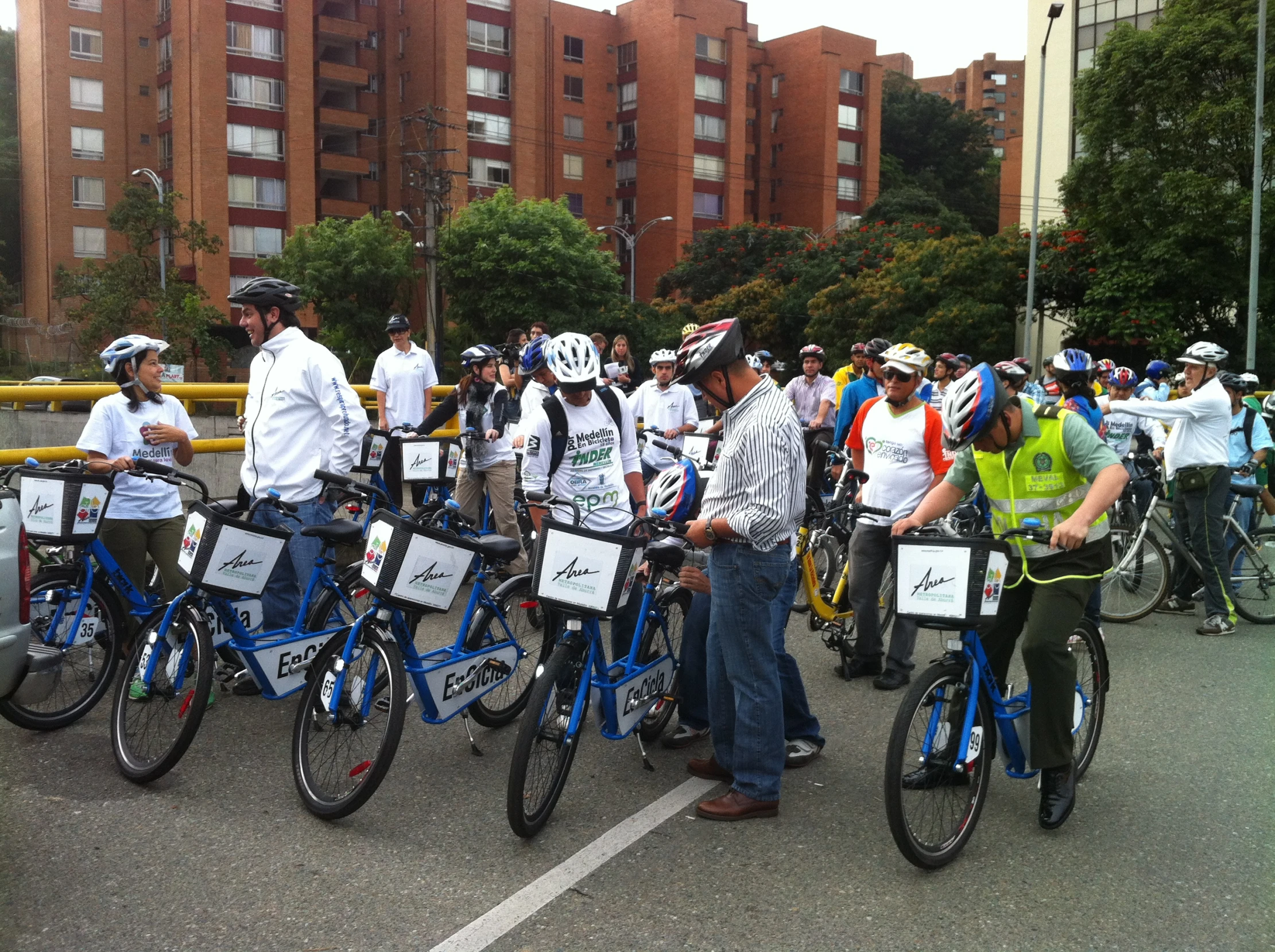 many people riding bikes and bicycles in a bike parking lot