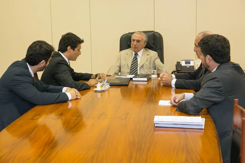 four business people sitting around a conference table together