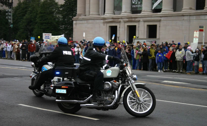 a motorcycle gang in helmets are driving past an audience