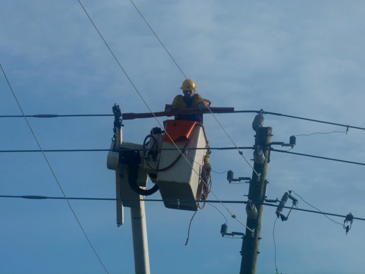 a man that is on top of a telephone pole