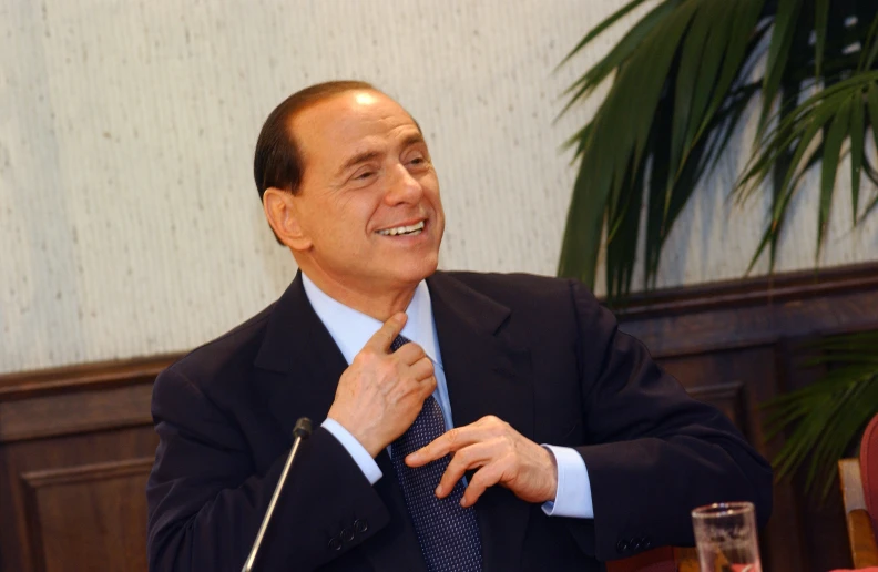 a man in suit smiling at a table