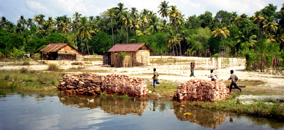 a man standing next to wooden logs on top of a river