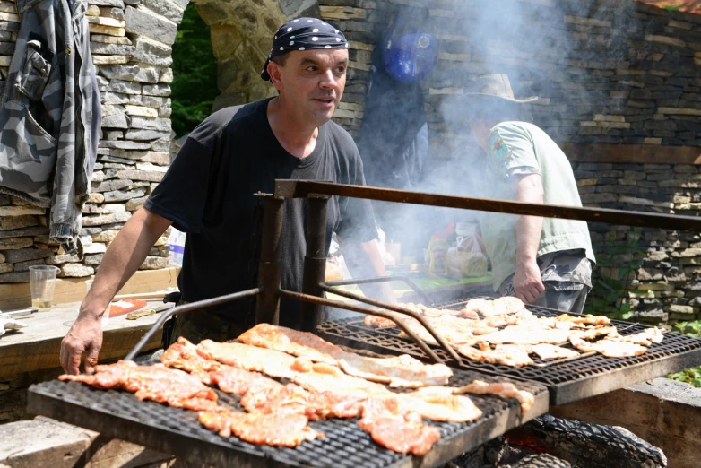 a man standing in front of a grill with  dogs on it