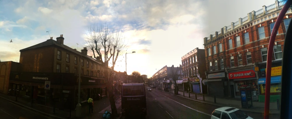 the sun is setting on a small street in europe