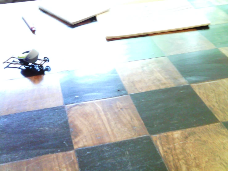 a wood floor with a small robot on top of it